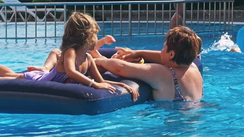 Smiling, happy children on a float in a swimming pool. Stock Footage 94696136