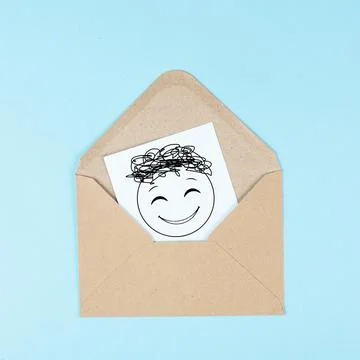 Smiling happy face on a paper inside an evelope, positive emotions, good Stock Photos