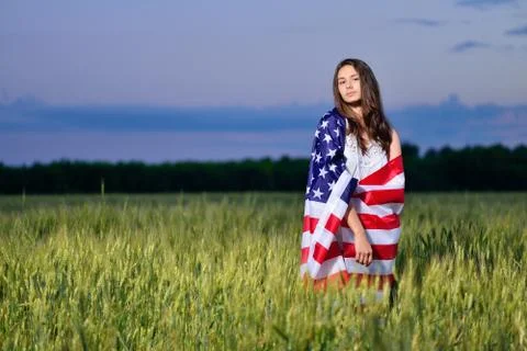 Smiling happy girl with the American flag on his shoulders. 4th july - Indepe Stock Photos