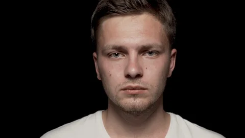 Smiling head of caucasian man looking at camera on black background. Stock Footage 110996720