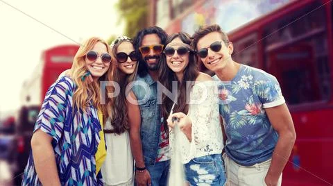 Smiling hippie friends with selfie stick in london Stock Photos