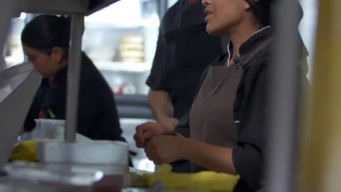 Smiling Hispanic chefs cooking in a restaurant kitchen Stock Footage 149212463