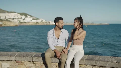 Smiling Hispanic couple talking while resting on embankment Stock Footage 162569776