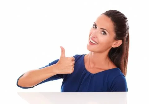 Smiling hispanic lady with thumb up while looking at you in white background Stock Photos