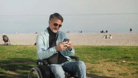 Smiling hispanic middle aged man hold use smart phone sitting outdoor at Stock Footage 248825190