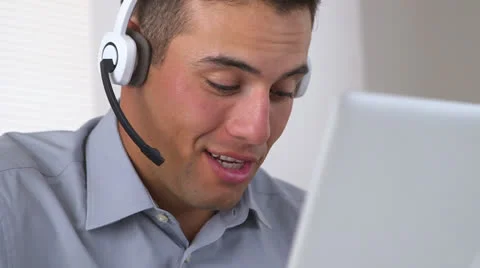 Smiling Hispanic telemarketer working at computer Stock Footage 26181692