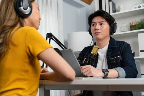 Smiling host holding tablet wearing headphone interview speaker. Infobahn. Stock Photos