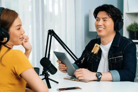 Smiling host holding tablet wearing headphone interview speaker. Infobahn. Stock Photos