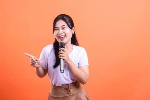Smiling Host with Microphone and Pointing Gesture Stock Photos