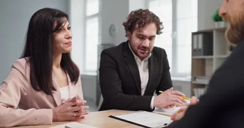 Smiling HR recruiter leads interview with candidate, colleague taking notes in Stock Footage 345666355