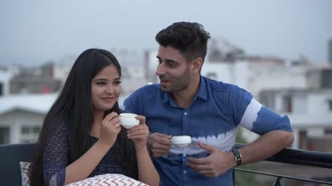 Smiling Indian couple having tea while enjoying pleasant talk at home,outdoors Stock Footage 148423646