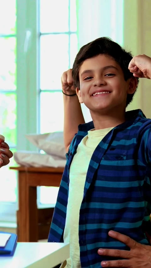 Smiling Indian dentist teaching young boy about strong teeth with a denture Stock Footage 342432787