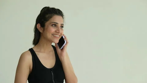 Smiling Indian female using cell phone calling while exercise. Video stock 197019979