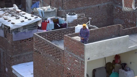 Smiling Indian Man Flying Kite From Rooftop in Amritsar, India Stock Footage 129587218