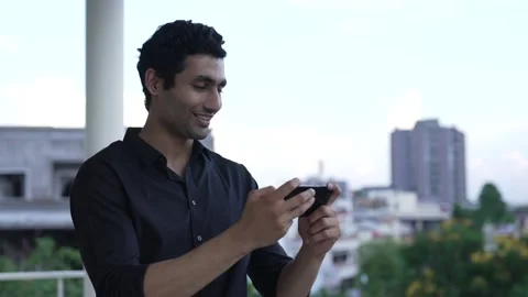 Smiling Indian man having fun chatting in social media. Видео 170429225