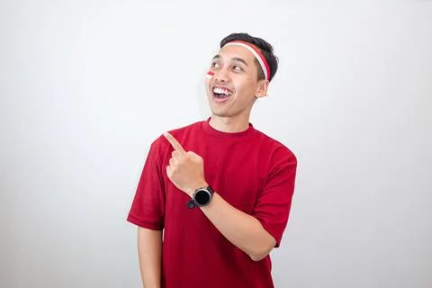 Smiling Indonesian Guy Pointing Sideways With Energetic And Cheerful Mood, .. Stock Photos