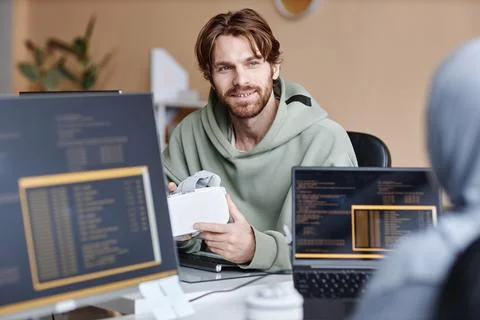 Smiling IT Developer Talking To Colleague in Office Stock Photos