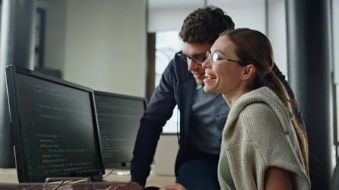 Smiling it intern discussing software code with supervisor. Friendly team work Foto stock