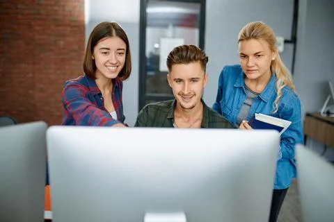 Smiling IT specialists works on computers, office Stock Photos