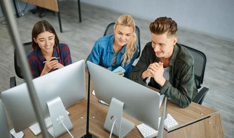 Smiling IT specialists works on computers, office Stock Photos