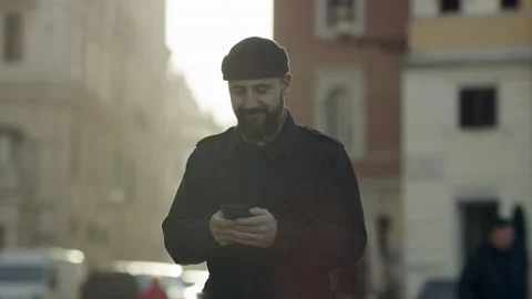 Smiling Italian man looking down and using his mobile phone in the middle of a s Stock Footage 199450579