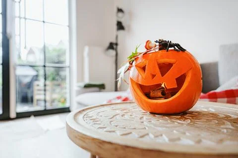 Smiling Jack O Lantern Decorated With Black Spider In Modern Interior 스톡 사진