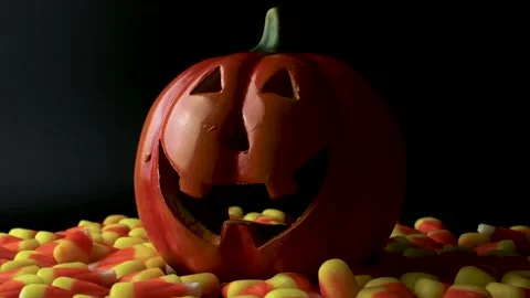 Smiling jack o lantern pumpkin carving surrounded by candy corn spinning Vídeos de archivo 208064473