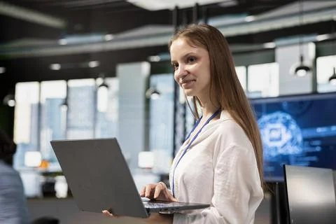 Smiling junior developer utilizing artificial intelligence to optimize Stock Photos