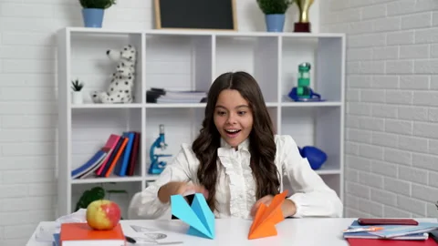 Smiling kid in school uniform started to play with origami paper planes Stock Footage 159535353