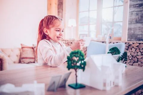 Smiling kid showing working windmill her parents Stock Photos