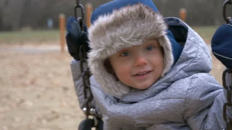 Smiling kid swaying on swing Stock Footage 98435409