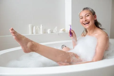 Smiling lady preparing to remove leg hair Stock Photos