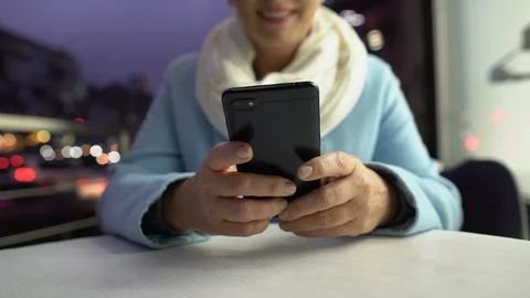 Smiling lady scrolling smartphone spending time on open terrace of cafe, closeup Vídeo Stock 119024012