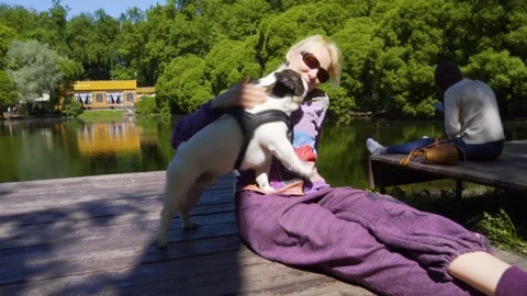Smiling lady taking free time with her dog. Woman relaxing in the nature with Stock Footage 108337808