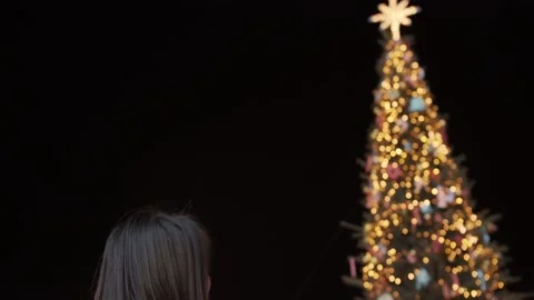 Smiling lady in warm clothes stands on a winter evening near a decorated Stock Footage 135155359
