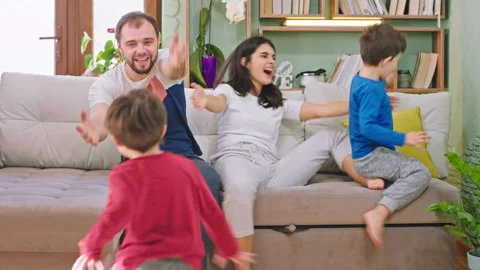 Smiling large mom and dad sitting on the sofa and waiting to for their running Stock Footage 139049140