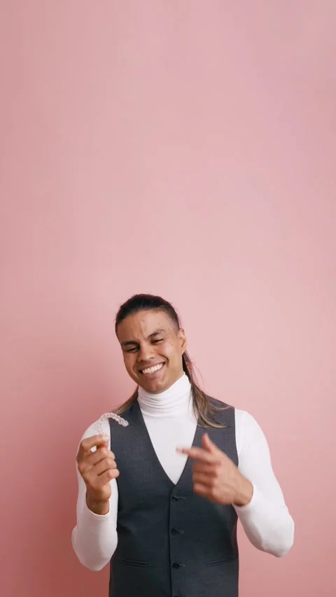 Smiling Latino man presenting invisible dental aligner. Vertical Stock Footage 333074356