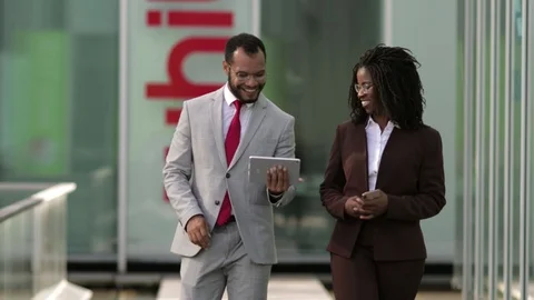 Smiling lawyers looking at tablet during stroll Stock Footage 114962330