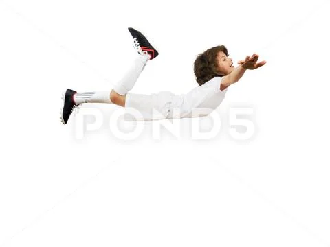 Smiling little boy in football uniform with arms raised simulating flight aga Stock Photos