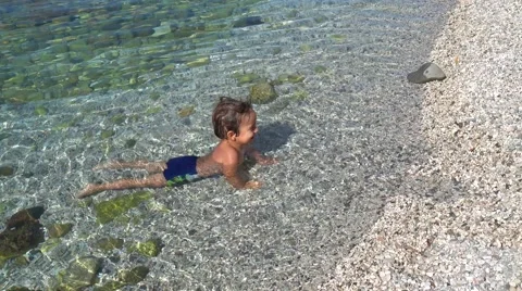 Smiling little frog dabbling in the sea Stock Footage