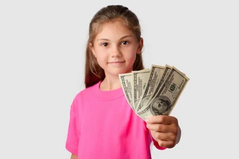 Smiling little girl giving a pack of money to a camera Stock Photos