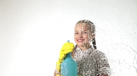 Smiling little housewife washed the window with a spray, cloth and detergent Stock Footage