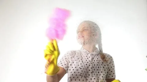 Smiling little housewife washed the window with a spray, cloth and detergent Stock Footage