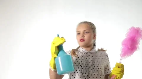 Smiling little housewife washing the window with a spray, cloth and detergent Stock Footage
