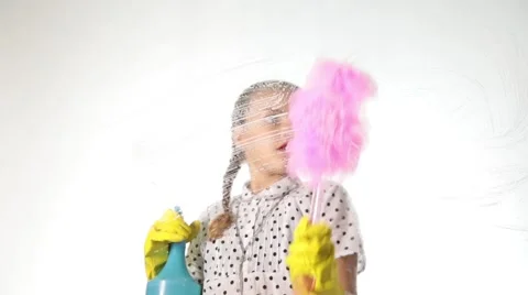 Smiling little housewife washing the window with a spray, cloth and detergent Stock Footage