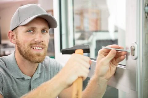 Smiling locksmith using a hammer Stock Photos