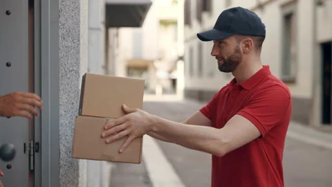 Smiling mailman courier delivering a parcel directly to a customer home. Stock Footage 141372229