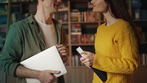 Smiling male and female students discussing research in university library Stock Footage 340266617