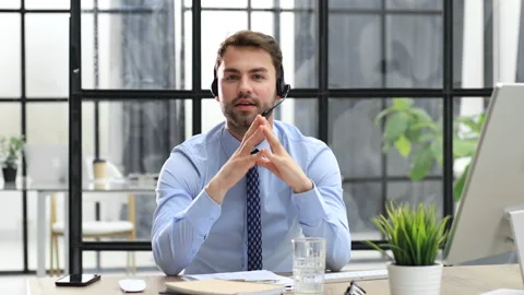 Smiling male call-center operator with headphones sitting at modern office Stock Footage 201997670