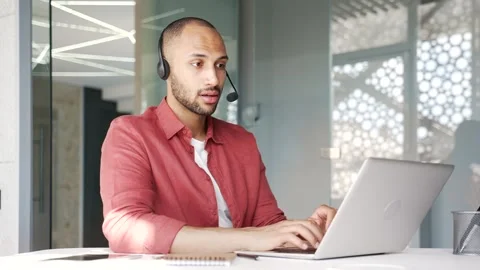 Smiling male corporate operator in headset working in customer support service  Vidéo 340880606